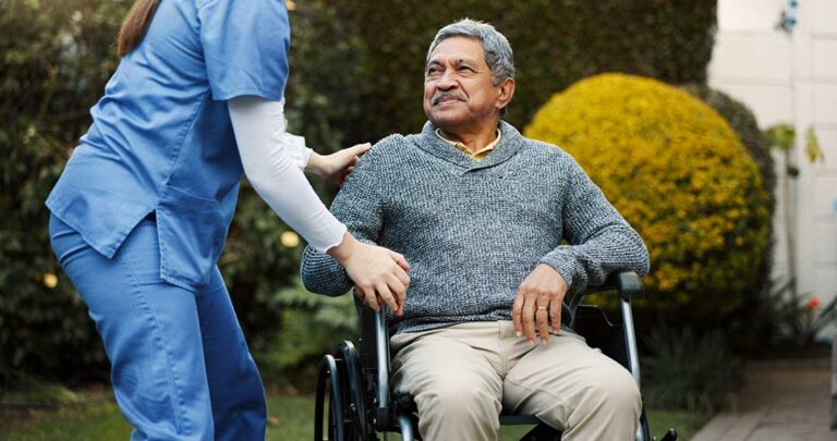 Older adult arranging personal belongings in a bright assisted living apartment with family nearby